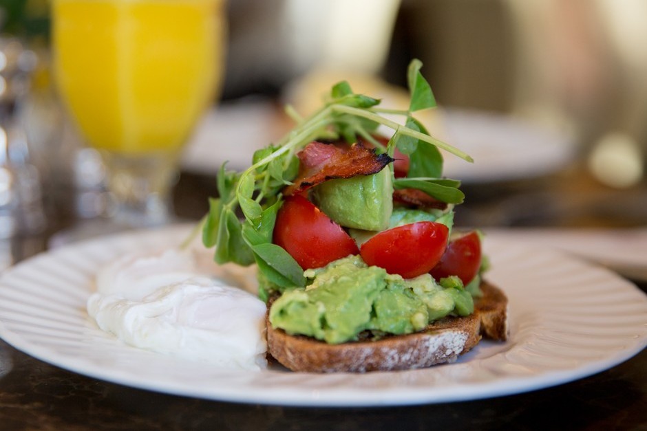 Smashed avocado on sourdough toast with bacon, cherry tomatoes, pea shoots and a poached egg at Bettys, York
